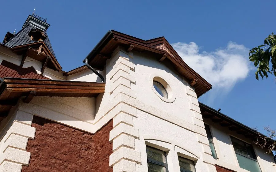 Two-story home exterior with painted white stucco quoins, stained wood fascia and soffits, Palm Beach Gardens, FL