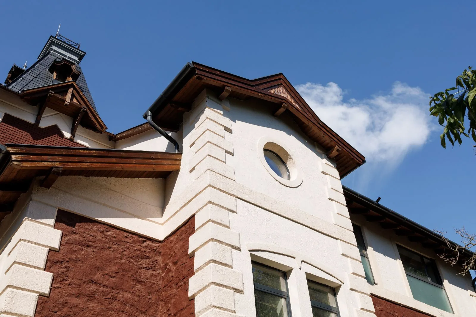 Two-story home exterior with painted white stucco quoins, stained wood fascia and soffits, Palm Beach Gardens, FL