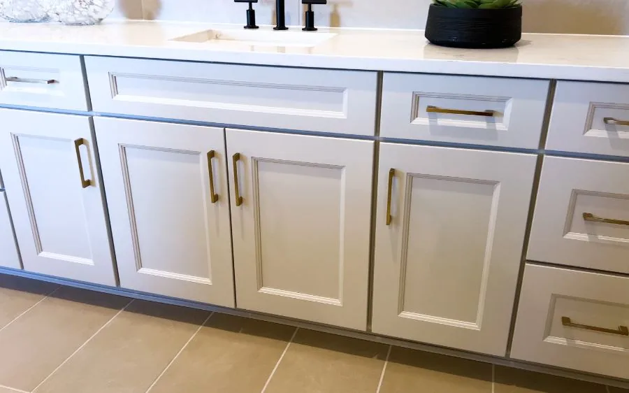 Freshly painted light gray bathroom vanity cabinets with brass pulls and a quartz countertop, West Palm Beach, FL