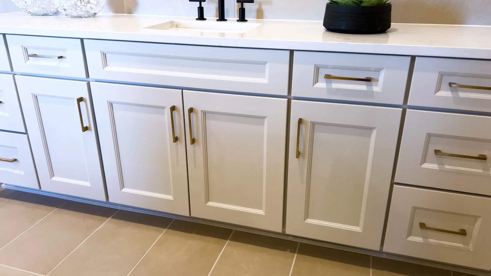 Freshly painted light gray bathroom vanity cabinets with brass pulls and a quartz countertop, West Palm Beach, FL