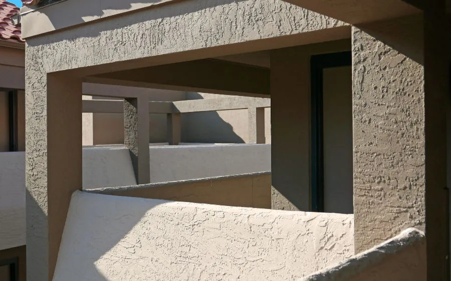 Freshly repainted textured stucco balconies and columns in warm tan on a residential building, West Palm Beach, FL