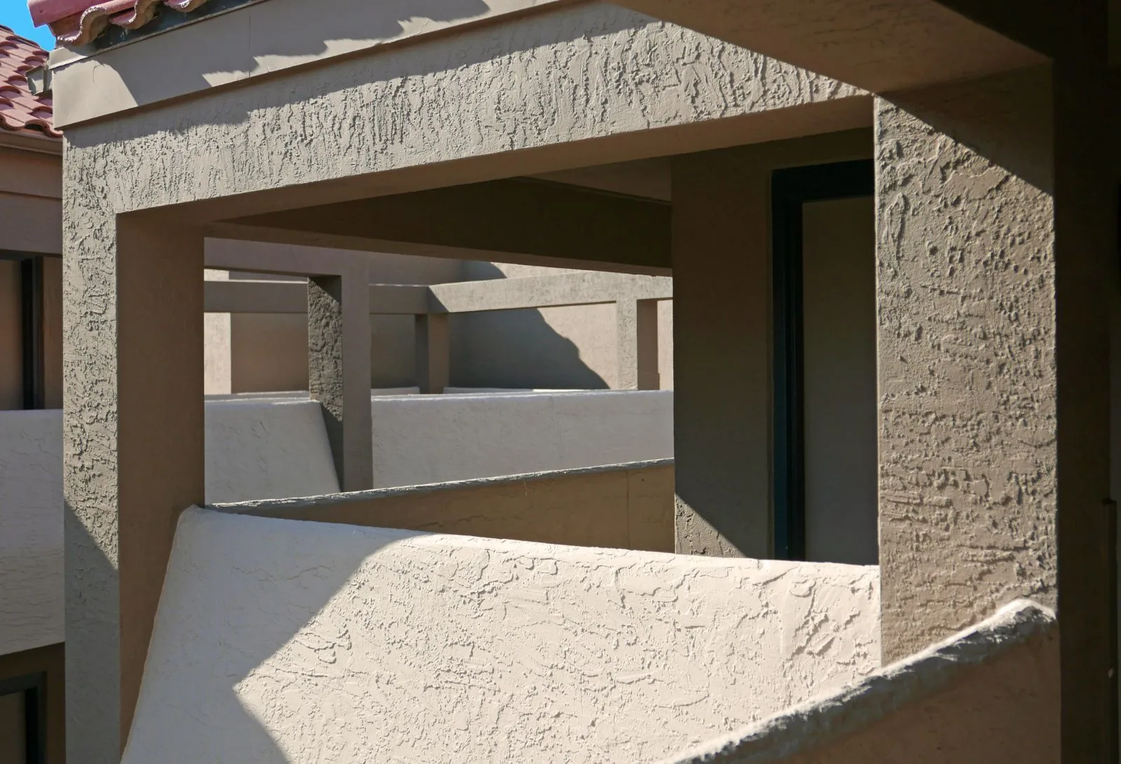 Freshly repainted textured stucco balconies and columns in warm tan on a residential building, West Palm Beach, FL