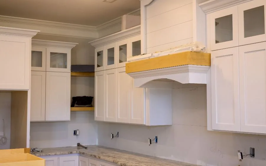 White shaker cabinets and a wood range hood mid-repaint in a kitchen, Boca Raton, FL